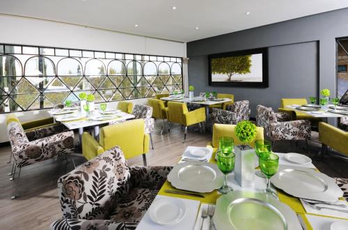 萨卡特卡斯Hotel & Spa Hacienda Baruk的用餐室配有桌子和黄色椅子
