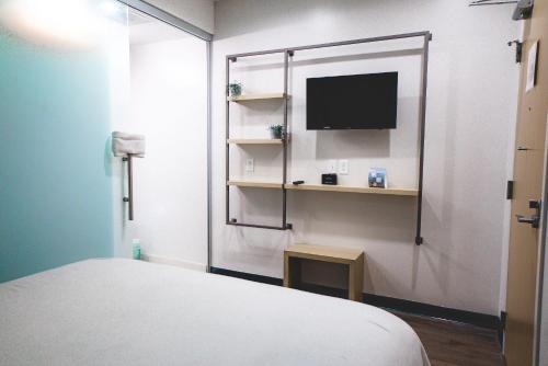 达拉斯SOVA Micro-Room & Social Hotel的小房间设有床铺和电视