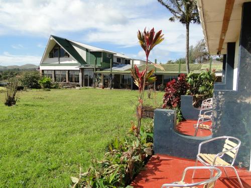 安加罗阿图帕酒店的一座房子,配有两把椅子和草地庭院