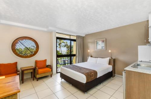 汤斯维尔滨水斯特兰德酒店的酒店客房带一张床和一个厨房