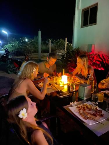 Fehendhoo奥利维葛德霍旅馆的一群坐在餐桌上吃食物的人
