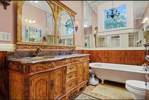 莫比尔McKean Manor的浴室配有木制梳妆台、浴缸和盥洗盆。