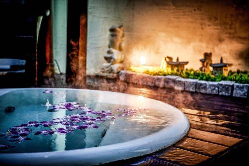 川崎Hotel Balian Resort Tomei Kawasaki I.C.的浴缸里装满了紫色花卉的水