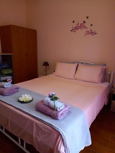 尼亚普拉莫斯Peramos Apartments的一间卧室配有带毛巾和鲜花的床