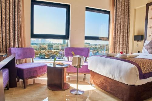 迪拜Carlton Dubai Creek Hotel的一间卧室配有紫色家具和大窗户
