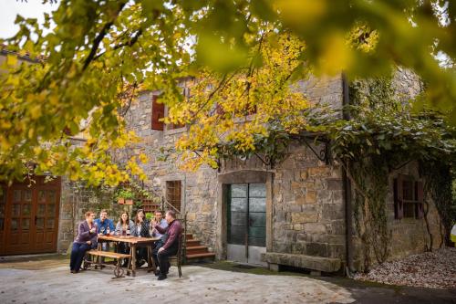 DekaniBordon wines, estate with accommodation的一群人坐在石头建筑前面的桌子上