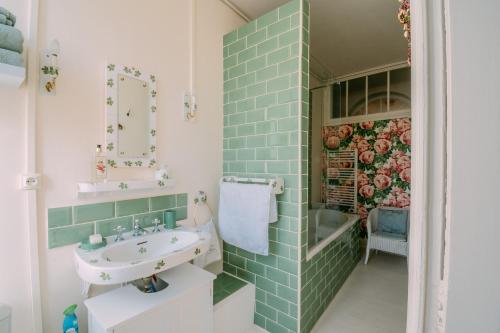 巴巴斯特La Maison 64 Chambre D'Hôtes的浴室设有绿色瓷砖和水槽