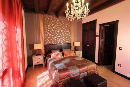 ArgésCasa Rural El Rosal del Pozo, a 5 minutos de Puy du Fou的一间卧室配有一张大床和一个吊灯。