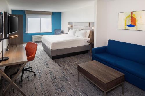 洛斯阿拉莫斯洛斯阿拉莫斯埃特拉达公园智选假日酒店的酒店客房,配有床和蓝色的沙发