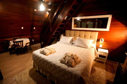 圣安东尼奥-杜皮尼亚尔Pousada Alpes的一间卧室配有一张床,上面有两条毛巾