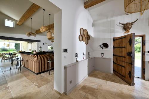 圣马迪拉莫Mas du Couvin, maison d'hôtes en Camargue的一间厨房和带白色墙壁及木门的用餐室