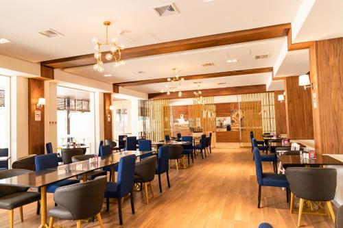 塔克纳DM Hoteles Tacna的一间配备有桌子和蓝色椅子的用餐室