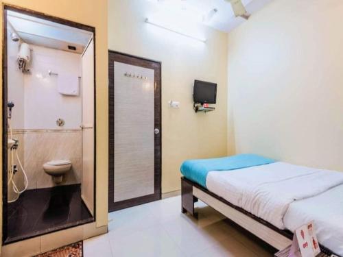 孟买Hotel Broadway Colaba的一间卧室配有一张床,浴室设有淋浴。