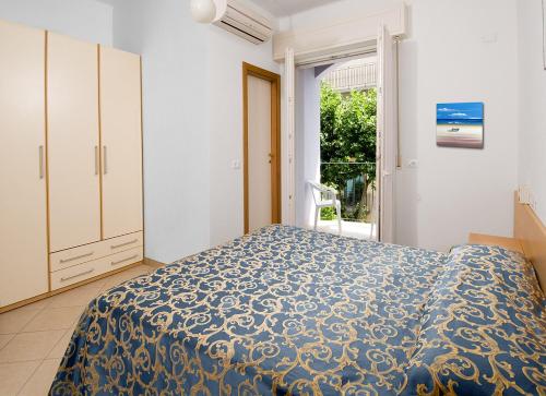 卡托利卡Hotel Mirabella的一间卧室配有一张带蓝色棉被的床