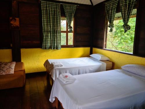 San MiguelLos Gallitos Eco Lodge的客房设有两张床和窗户。
