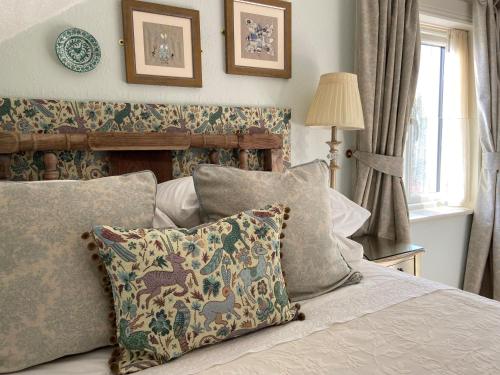 萨顿都柏林艺术家住宿加早餐旅馆的卧室配有带枕头的床铺和窗户。
