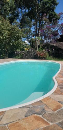 PalmitalCasa Refúgio da floresta na Serra的庭院里的一个蓝色海水大型游泳池