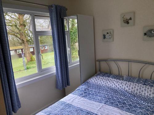 Kilkhampton13 The Park的一间卧室设有一张床和两个窗户。