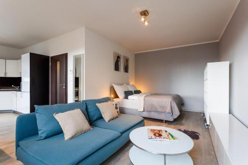 俄斯特拉发Golden Apartments Rezidence Nová Karolina II.的客厅配有蓝色的沙发和床。