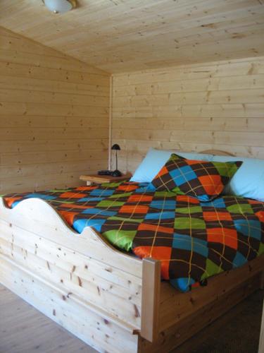 戈尔登Tschurtschenthaler Rentals的小木屋内的一张床位,配有色彩缤纷的被子