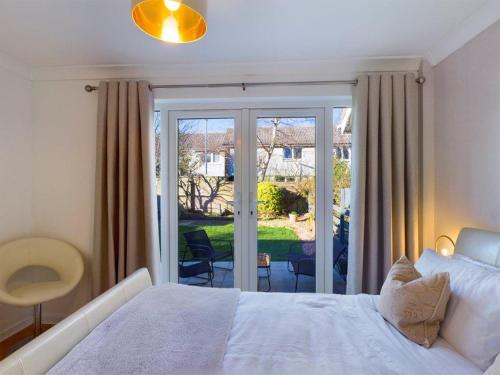 金斯巴恩斯Scotchacre Kingsbarns - Walk to Beach & Golf Club的卧室配有白色的床和滑动玻璃门