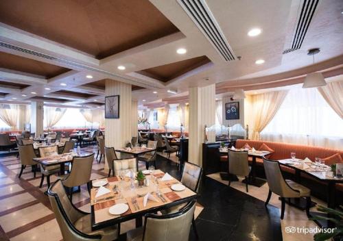 马斯喀特Garden Hotel Muscat By Royal Titan Group的餐厅内带桌椅的用餐室