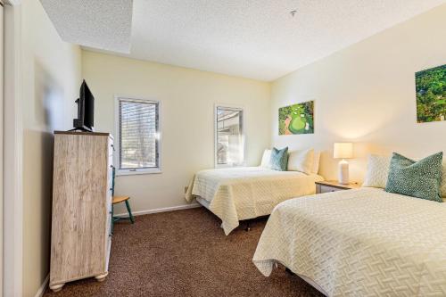 北默特尔海滩Tidewater Condos的一间卧室设有两张床和两个窗户。