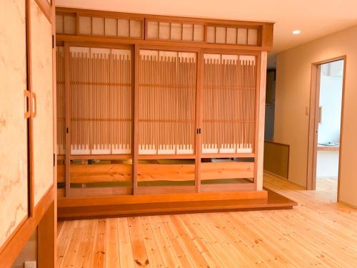 白老町Oceanview 貸別荘Hosuikan的一间设有玻璃门的客房和一间铺有木地板的客房