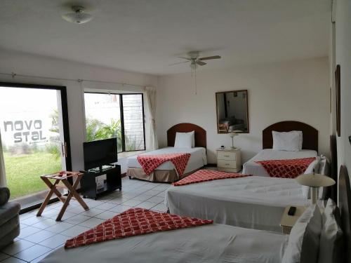 危地马拉Novohostal B&B的一间酒店客房,设有两张床和电视