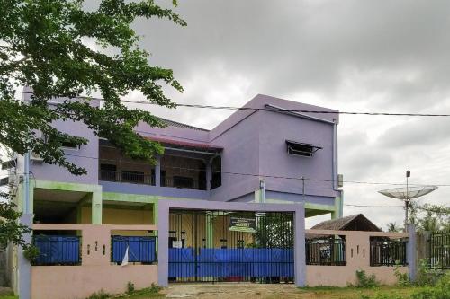 KadangHabieb Homestay Syariah near Fakultas Kedokteran Universitas Malikussaleh Mitra RedDoorz的紫色房子前面有一个蓝色的门