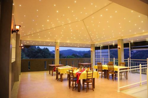 康提Crown & Crown Kandy的餐厅设有桌椅和天花板上的灯光