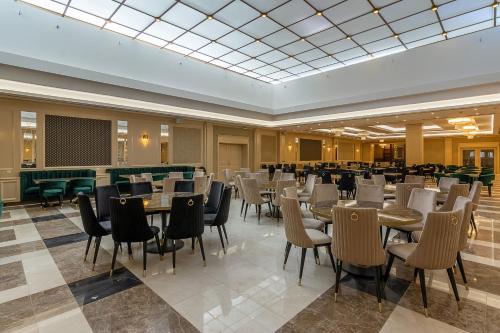 索非亚Astoria Grand Hotel的一间在房间内配有桌椅的餐厅