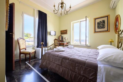 波佐利Villa Emilia的一间卧室配有一张床、一把椅子和窗户。