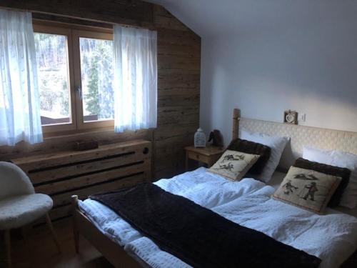 Versegeres The cosy Isba - Chambre d hôtes - Val de Bagnes - Verbier的一间卧室设有一张大床和一个窗户。