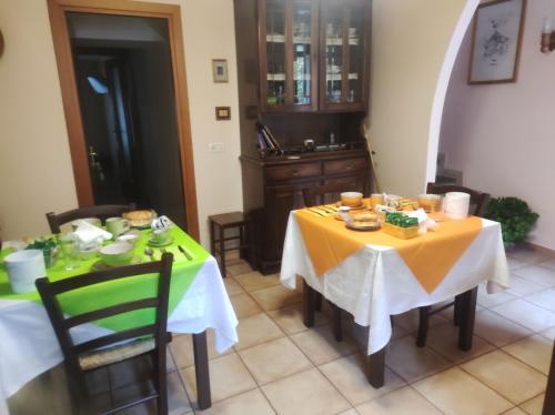 巴尼奥雷焦拉洛盖塔住宿加早餐旅馆的一间用餐室,配有两张带黄桌布的桌子