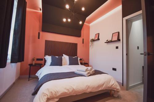 切斯特Central Stays - Luxury 3 Bedroom House in Central Chester SLEEPS 6的一间卧室拥有橙色的墙壁和一张大床