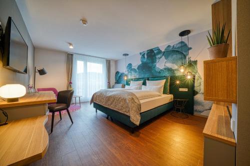 弗莱堡FourSide Hotel Freiburg的配有一张床和一张书桌的酒店客房
