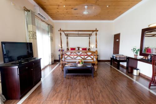 康提Kings Ridge Kandy的客厅配有床和平面电视