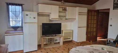 BastelicacciaCharmant T2的带冰箱的厨房和电视。