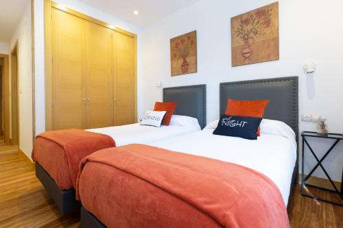 毕尔巴鄂Unamuno by Bilbao Living的两张带橙色枕头的床