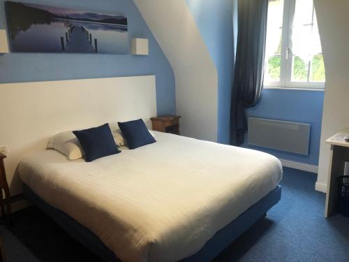 布雷斯特滨海之家酒店的一间卧室配有一张带蓝色墙壁的大床