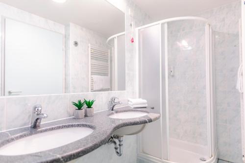 卡特兹奥布萨维Hotel Čatež - Terme Čatež的一间带两个盥洗盆和淋浴的浴室