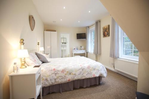朗塞斯顿Trelaske Manor B&B的一间卧室配有一张床、一张书桌和一个窗户。