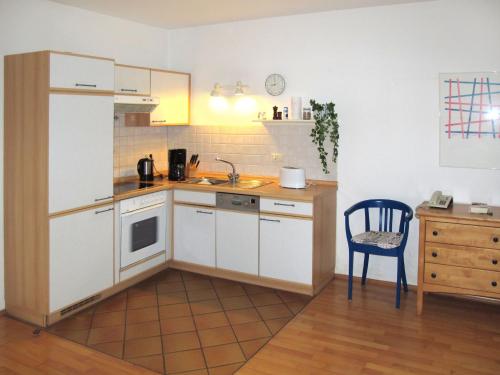 朱列斯拉赫Apartment Juliusruh-3 by Interhome的厨房配有白色橱柜和蓝色椅子