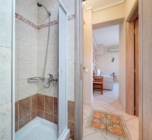 奥林匹亚达En Iko Christianna的浴室里设有玻璃门淋浴