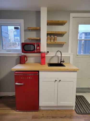 Stylish one bedroom Apartment.的厨房配有红色冰箱和微波炉