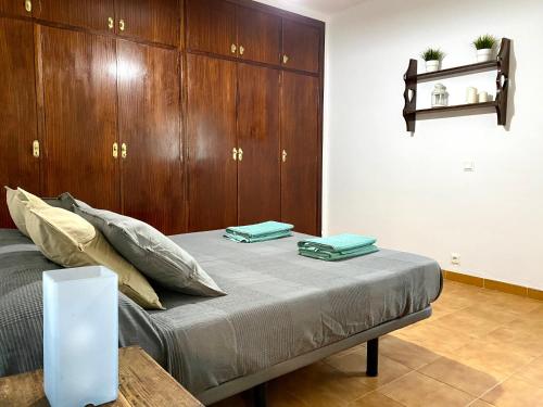 皮萨拉LAS PALMERAS的一间卧室配有一张带木橱柜的床。