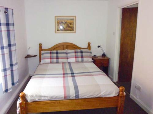 毕晓普斯堡Harley Apartment的一间卧室配有一张带条纹枕头的木床