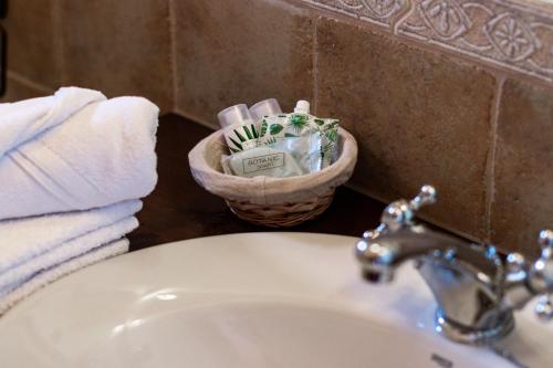 Salinas de HozHotel Rural La Sal的浴室水槽,内配毛巾篮和牙刷