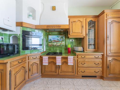 马赛Apartment La Maison de Protis - MSE100 by Interhome的厨房配有木制橱柜和炉灶烤箱。
